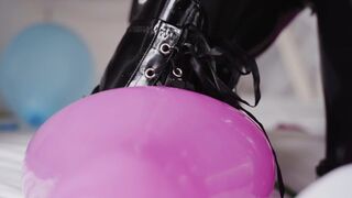 Play with balloons in a latex catsuit