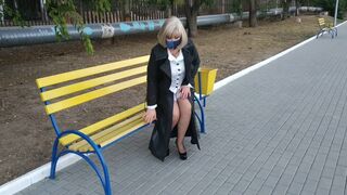 Slut walking in the park in a raincoat and black fishnet stockings with a white elastic band