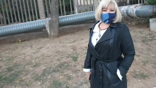 Slut walking in the park in a raincoat and black fishnet stockings with a white elastic band