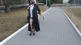 Slut walking in the park in a raincoat and black fishnet stockings with a white elastic band