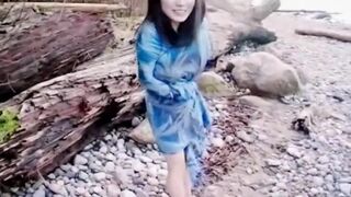 Asian slut is on the beach naked posing