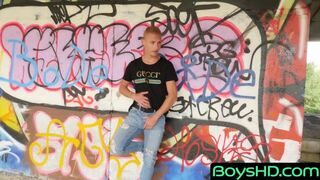 A young man makes out in front of a graffiti wall