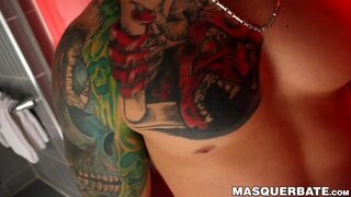 Tattooed athletic man with mask strokes his enormous dick