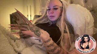 Inked Blonde Bombshell Holding Toys in Bed