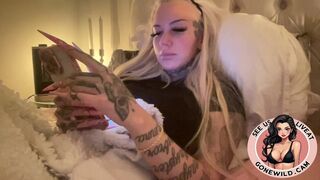 Inked Blonde Bombshell Holding Toys in Bed