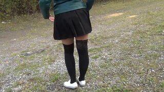 Schoolgirl in black knee socks and white shoes show under the skirt